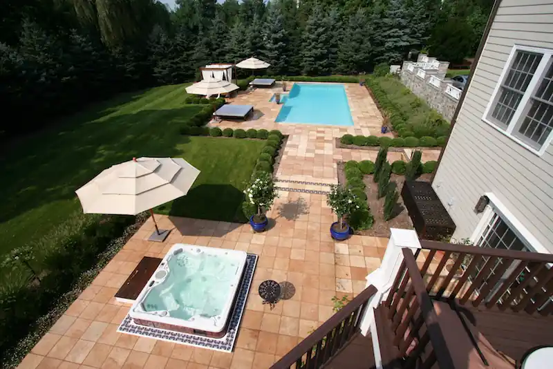 Aerial view of a long pool and a hot tub on a terracotta patio