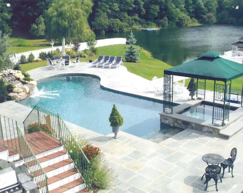 Lagoon-style pool with a gazebo and a lake behind